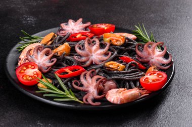 Siyah zemin üzerinde karides, ahtapot ve midye olan siyah deniz ürünleri makarnası. Akdeniz gurme yemekleri. Siyah ahtapot kaplı siyah makarna.