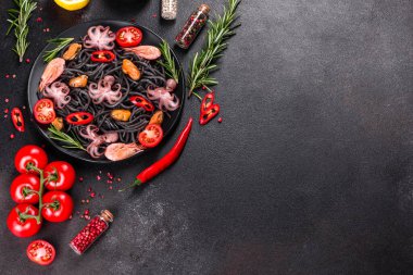 Siyah zemin üzerinde karides, ahtapot ve midye olan siyah deniz ürünleri makarnası. Akdeniz gurme yemekleri. Siyah ahtapot kaplı siyah makarna.