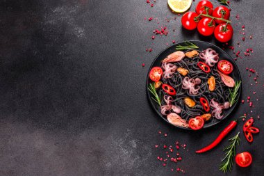 Siyah zemin üzerinde karides, ahtapot ve midye olan siyah deniz ürünleri makarnası. Akdeniz gurme yemekleri. Siyah ahtapot kaplı siyah makarna.