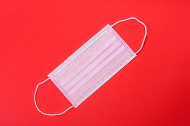 Renkli bir arka planda tıbbi maske, koronovirüs ve salgına karşı bir koruma aracı. Dünya çapında salgın, koruma
