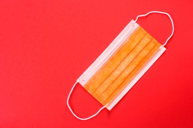 Renkli bir arka planda tıbbi maske, koronovirüs ve salgına karşı bir koruma aracı. Dünya çapında salgın, koruma