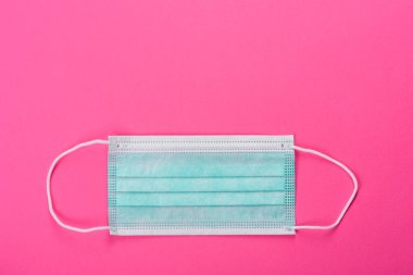 Renkli bir arka planda tıbbi maske, koronovirüs ve salgına karşı bir koruma aracı. Dünya çapında salgın, koruma
