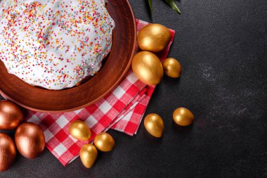 Paskalya yumurtası, altın, bronz ve arka planda Paskalya pastası. Tatil için hazırlık