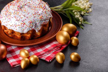 Paskalya yumurtası, altın, bronz ve arka planda Paskalya pastası. Tatil için hazırlık