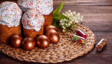 Paskalya yumurtası, altın, bronz ve arka planda Paskalya pastası. Tatil için hazırlık