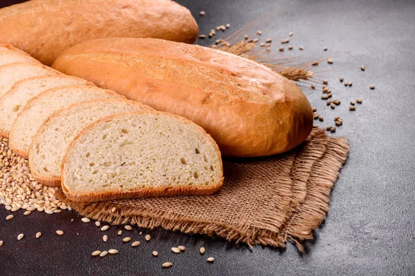 Fresh baked white bread on a brown concrete background. Freshly baked traditional bread on a dark background
