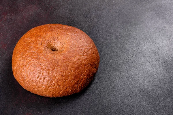 在棕色混凝土背景上新鲜烘烤的棕色面包 深色背景下新鲜烘焙的传统面包 — 图库照片