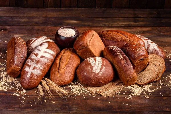 Fresh baked brown bread on a brown concrete background. Freshly baked traditional bread on a dark background