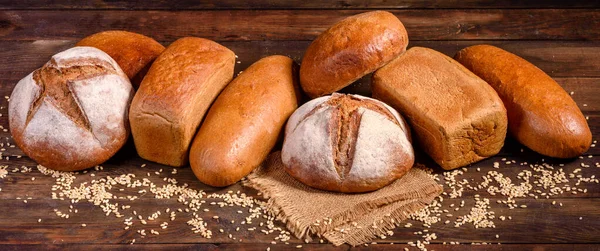 Fresh baked brown bread on a brown concrete background. Freshly baked traditional bread on a dark background