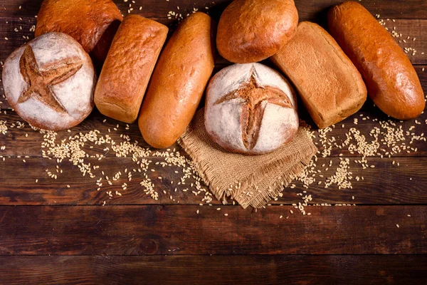 Fresh baked brown bread on a brown concrete background. Freshly baked traditional bread on a dark background