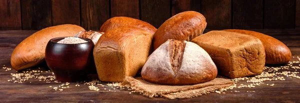 Fresh baked brown bread on a brown concrete background. Freshly baked traditional bread on a dark background