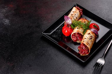 Lezzetli taze et tartartarı ve siyah bir tabakta siyah bir arka planda kızarmış ekmek.