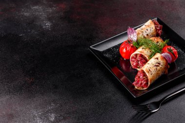 Lezzetli taze et tartartarı ve siyah bir tabakta siyah bir arka planda kızarmış ekmek.