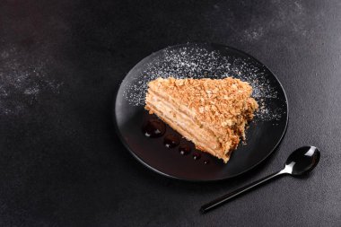 Koyu arkaplanda kremalı taze nefis kek Napolyonu. Kablo ve kremadan oluşan pasta