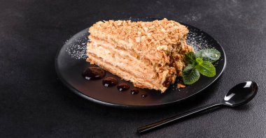 Koyu arkaplanda kremalı taze nefis kek Napolyonu. Kablo ve kremadan oluşan pasta