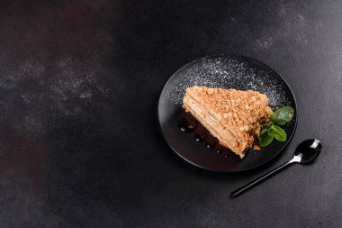 Koyu arkaplanda kremalı taze nefis kek Napolyonu. Kablo ve kremadan oluşan pasta