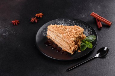 Koyu arkaplanda kremalı taze nefis kek Napolyonu. Kablo ve kremadan oluşan pasta