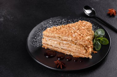 Koyu arkaplanda kremalı taze nefis kek Napolyonu. Kablo ve kremadan oluşan pasta