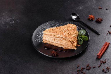 Koyu arkaplanda kremalı taze nefis kek Napolyonu. Kablo ve kremadan oluşan pasta