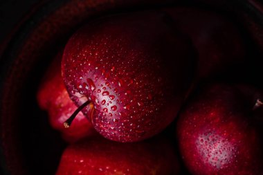 Koyu arkaplan ve metin için alanı olan su damlacıkları ile taze sulu kırmızı elma