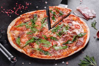 Fırında roka, salam, vişneli domates ve mozzarella ile pişirilmiş taze pizza. İtalyan mutfağı