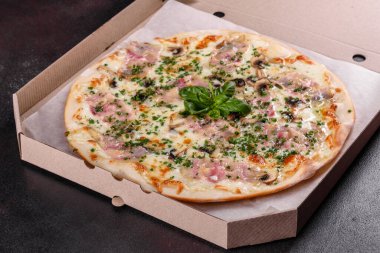 Fırında jambonlu, soğanlı, yeşillikli ve domatesli taze pizza. İtalyan mutfağı