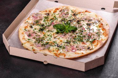 Fırında jambonlu, soğanlı, yeşillikli ve domatesli taze pizza. İtalyan mutfağı