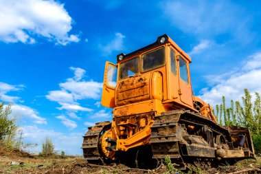 Endüstriyel inşaat alanı buldozer otoyol inşaatı sırasında toprağı düzleştiriyor ve hareket ettiriyor. İğrenç bir şantiyede sarı buldozer.