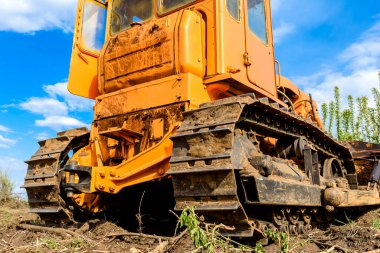 Endüstriyel inşaat alanı buldozer otoyol inşaatı sırasında toprağı düzleştiriyor ve hareket ettiriyor. İğrenç bir şantiyede sarı buldozer.