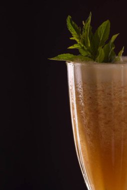 Siyah zemin üzerinde kokteyl tüpü olan soğuk, ferahlatıcı papaya buzu.