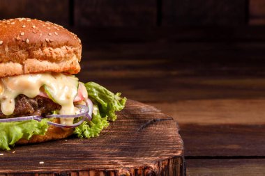 Et, domates, peynir, salatalık ve marullu ev yapımı lezzetli bir hamburger. Lezzetli ızgara burger.