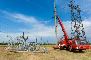 Güneşli bir yaz gününde mavi gökyüzünün arka planına yüksek voltajlı elektrik hattı kurulumu