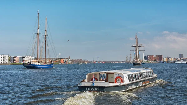 Amsterdam Merkez İstasyonu'nun arkasında nehir IJ gemilerde.