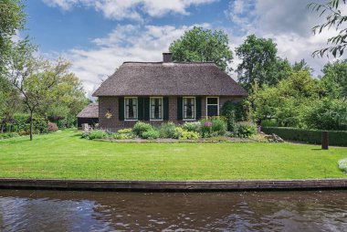 Kanal boyunca bir thatched çatı ile eski çiftçi ev.