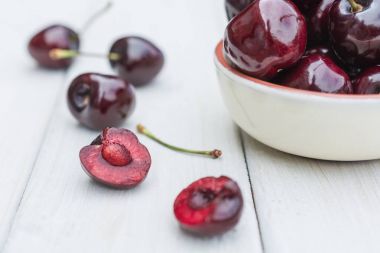 Ahşap bir masa üzerinde kiraz reçeli cam dolu