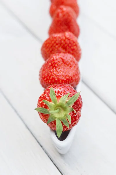 Olivenboot gefüllt mit Erdbeeren auf einem Holztisch — Stockfoto