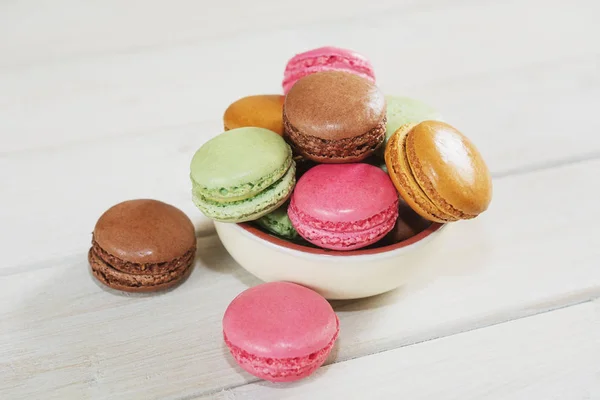 Bowl filled with macaroons with the flavors of coffee, pistachio, chocolate and raspberries. — Stock Photo, Image