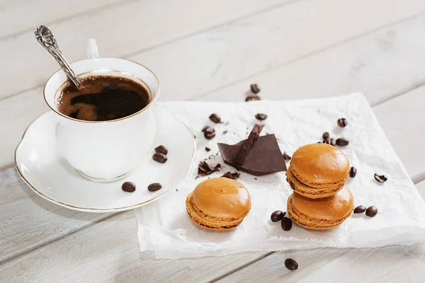 Çikolata parçaları ile bir fincan kahve beyaz bir peçeteye sundu