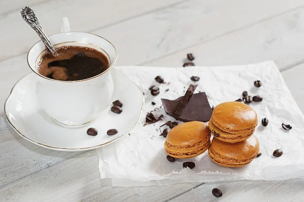 Çikolata parçaları ile bir fincan kahve beyaz bir peçeteye sundu