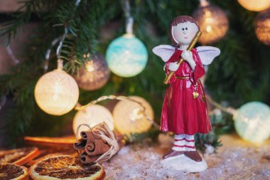 Angel bir Noel şube önünde flüt ile ışıklı Noel topları ile dekore edilmiştir.