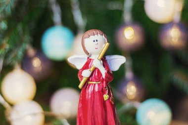 Angel bir Noel şube önünde flüt ile Noel topları ile dekore edilmiştir.