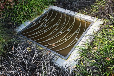 Su birikintisi bir dekoratif demir ızgara ile kaplı