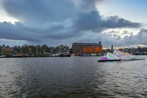 Floating artwork of light at Oosterdok with the grandhotel Amrath Amsterdam in the background — Stock Photo, Image