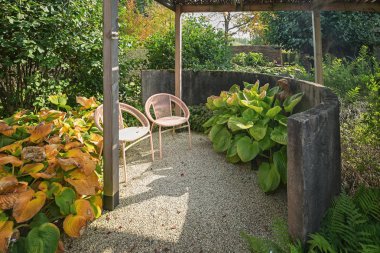 Güzel bir sonbahar Bahçe köşesinde güneşin tadını çıkarmak için iki sandalye