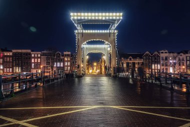 Magere eski merkezi Amsterdam karakteristik kanal binalarda içinde belgili tanımlık geçmiş ile Amstel Nehri üzerinde köprü.