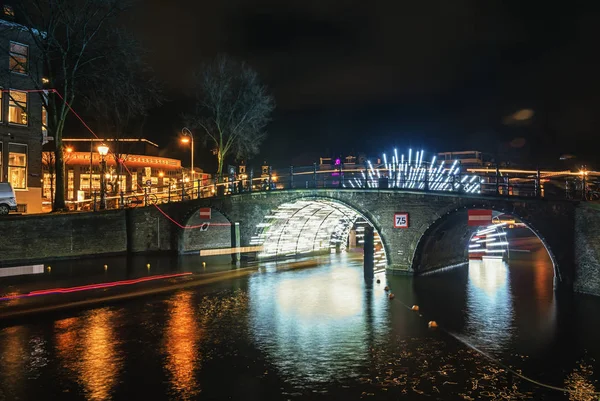 Túnel de luz bajo el puente sobre el canal Herengracht durante el Festival de la Luz en Ámsterdam — Foto de Stock