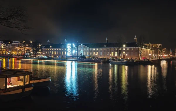 Museo Hermitage di Amsterdam con un oggetto d'arte leggera nel fiume Amstel — Foto Stock