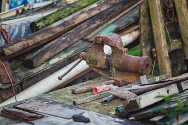 Paslı mengene ve çekiç arasında atık ahşap