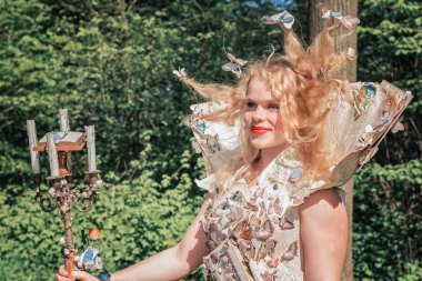 19 Nisan 2014, Haarzuilens, Hollanda: Kağıt elbise ile güzel giyimli Bayan dekore kelebekler pozlar parkta sırasında Elf fantezi kale de Haar açık fantezi Event'de olan Fuarı (Elfia)