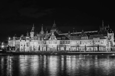 Hollanda 'daki Amsterdam Merkez İstasyonu' nun önündeki restoranın siyah beyaz fotoğrafı.